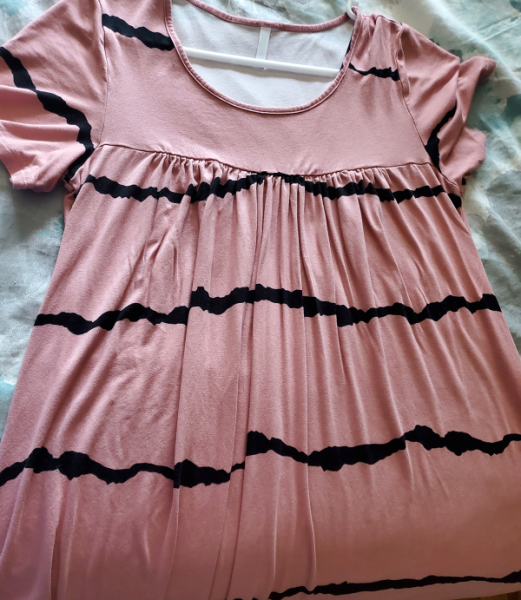 Pink womans shirt with black wavy horizontal scary lines