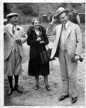 Former President Coolidge with a parrot as his wife and Mr. William Wrigley look on