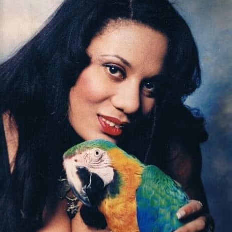 Attractive black woman holding a macaw parrot