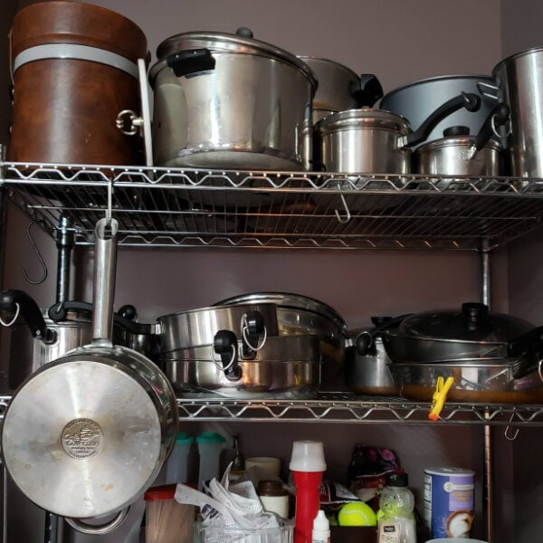 2 shelves of stainless cookware in kitchen