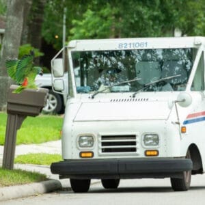 USPS truck next to mailbox with Amazon landing on it